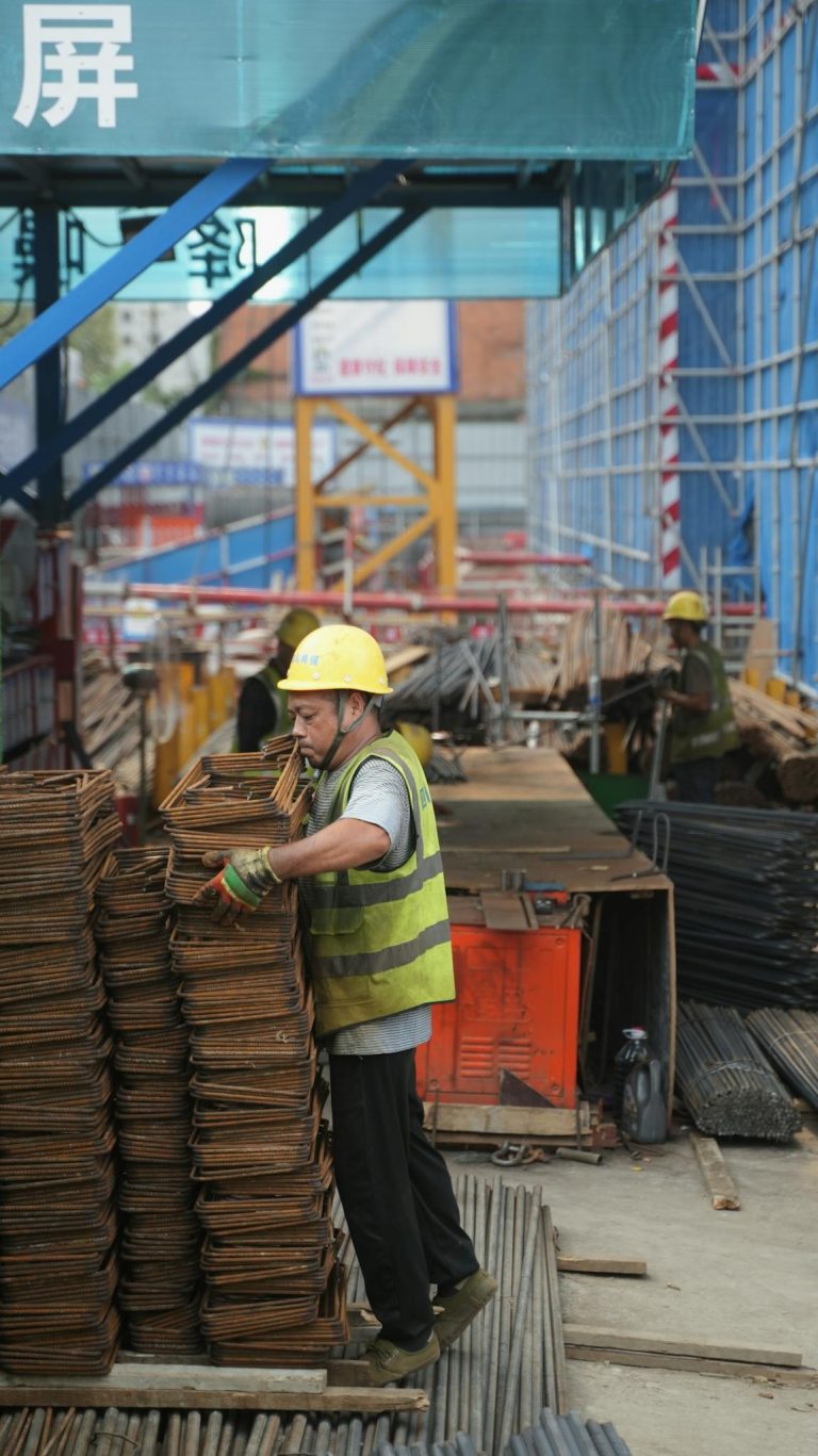 Workers manage steel materials at a bustling construction site in China.